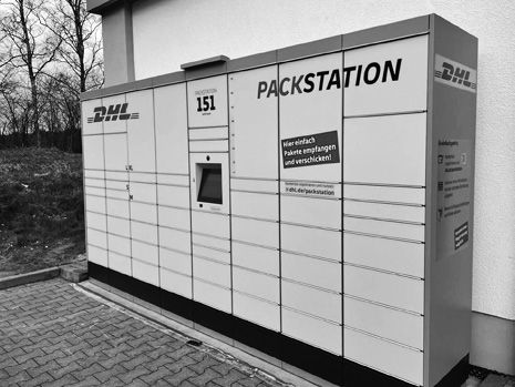Посылочный автомат, надпись: PACKSTATION (латиница), Германия. Слева виден логотип международной компании экспресс-доставки DHL