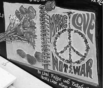 An open spiral notebook displays a drawing of a peace symbol made of flowers with the words "MAKE LOVE NOT WAR" alongside a bouquet of flowers and handwritten text below.

Description generated by AI